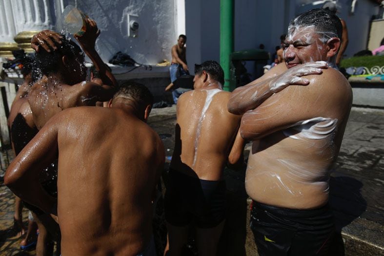 
Migrantes | Los migrantes centroamericanos que se dirigían a los EE. UU. En una gran caravana se bañan con agua de una boca de incendio en la plaza principal de Tapachula,. / AP
   