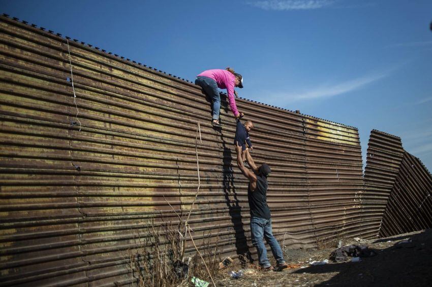 
Foto: AFP | Una familia de migrantes centroamericanos trepa la valla fronteriza entre México y Estados Unidos, en Tijuana, estado de Baja California, México, el 25 de noviembre de 2018.
   