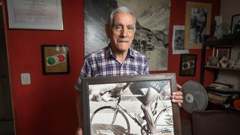 Ernesto con una fotografía de él en su bicicleta.