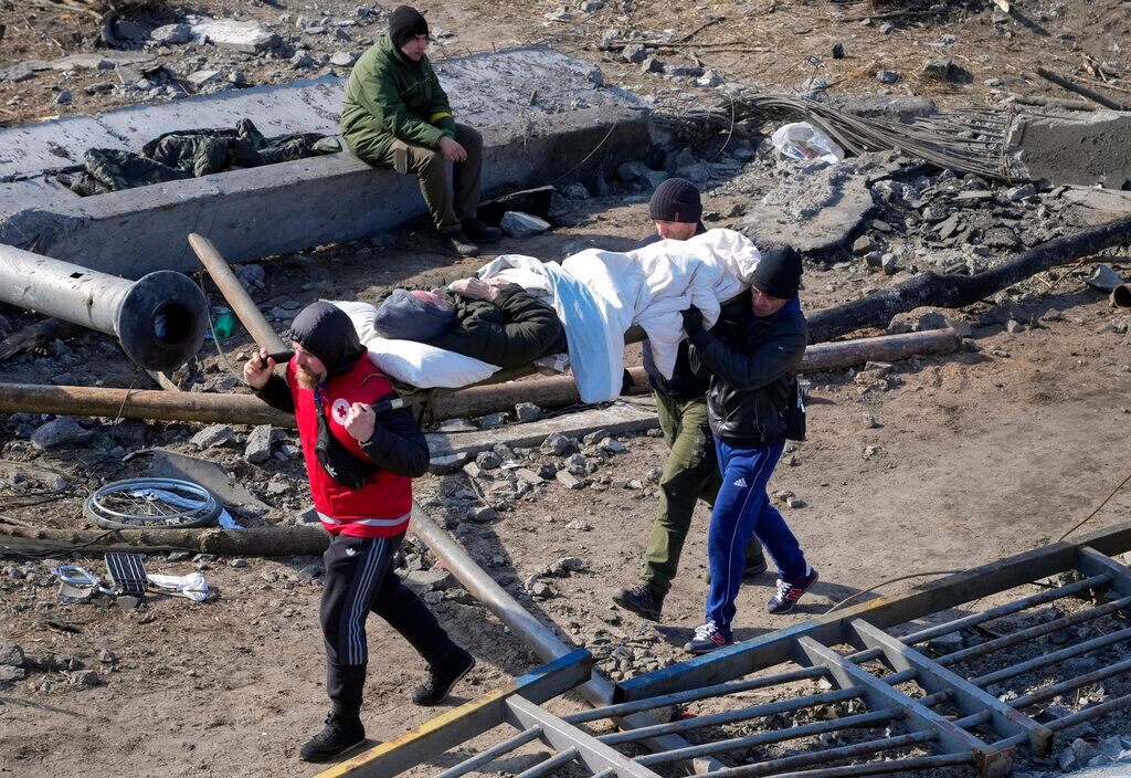 Voluntarios evacuan a un anciano residente en Irpín. Foto: AP / Efrem Lukatsky