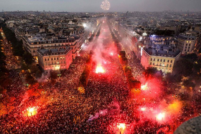 
Foto: AFP | Esta fotografía tomada desde la parte superior del Arco de Triunfo muestra a miles de franceses festejar el campeonato del mundo obtenido por la selección de Francia el 15 de julio de 2018.
   