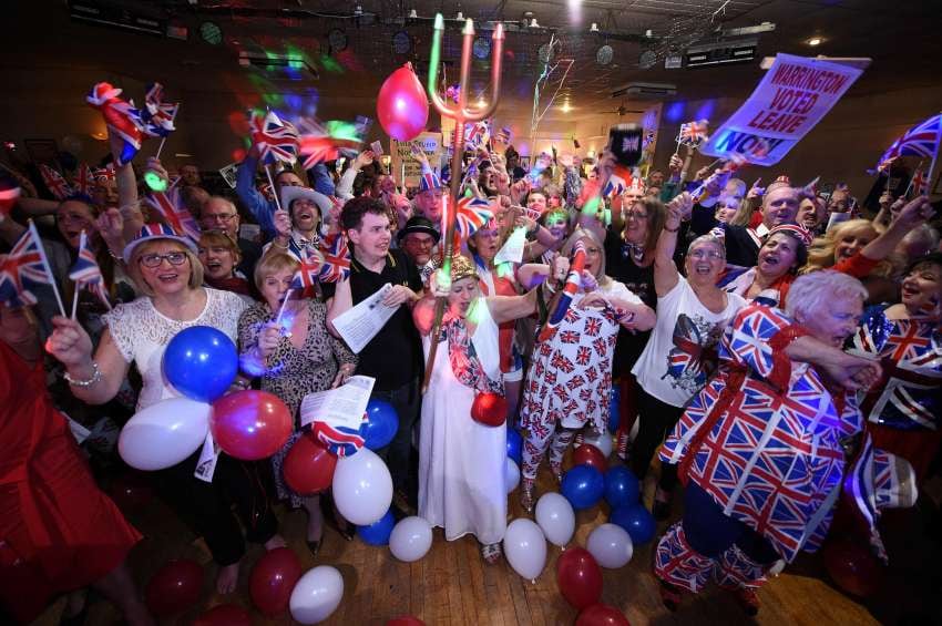 
Los partidarios del Brexit ondean banderas de la Unión en una fiesta en el Woolston Social Club en Warrington, noroeste de Inglaterra | AFP
   