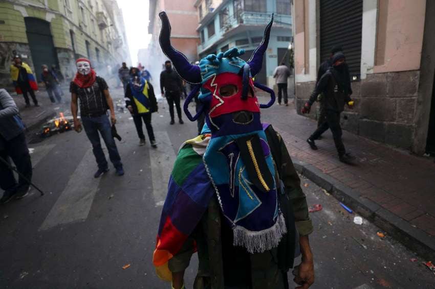 
Foto: AP | Un manifestante antigubernamental usa una máscara folclórica.
   