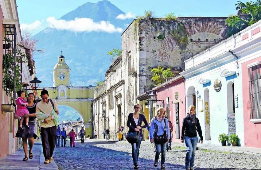 
    Antigua. Las pintorescas fachadas coloniales, el Arco de Santa Catalina y, de fondo, la silueta del Volcán de Agua.
   