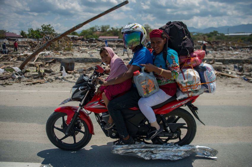 
    Una familia viaja en una motocicleta a través de un área devastada en Palu, Sulawesi Foto AFP
   