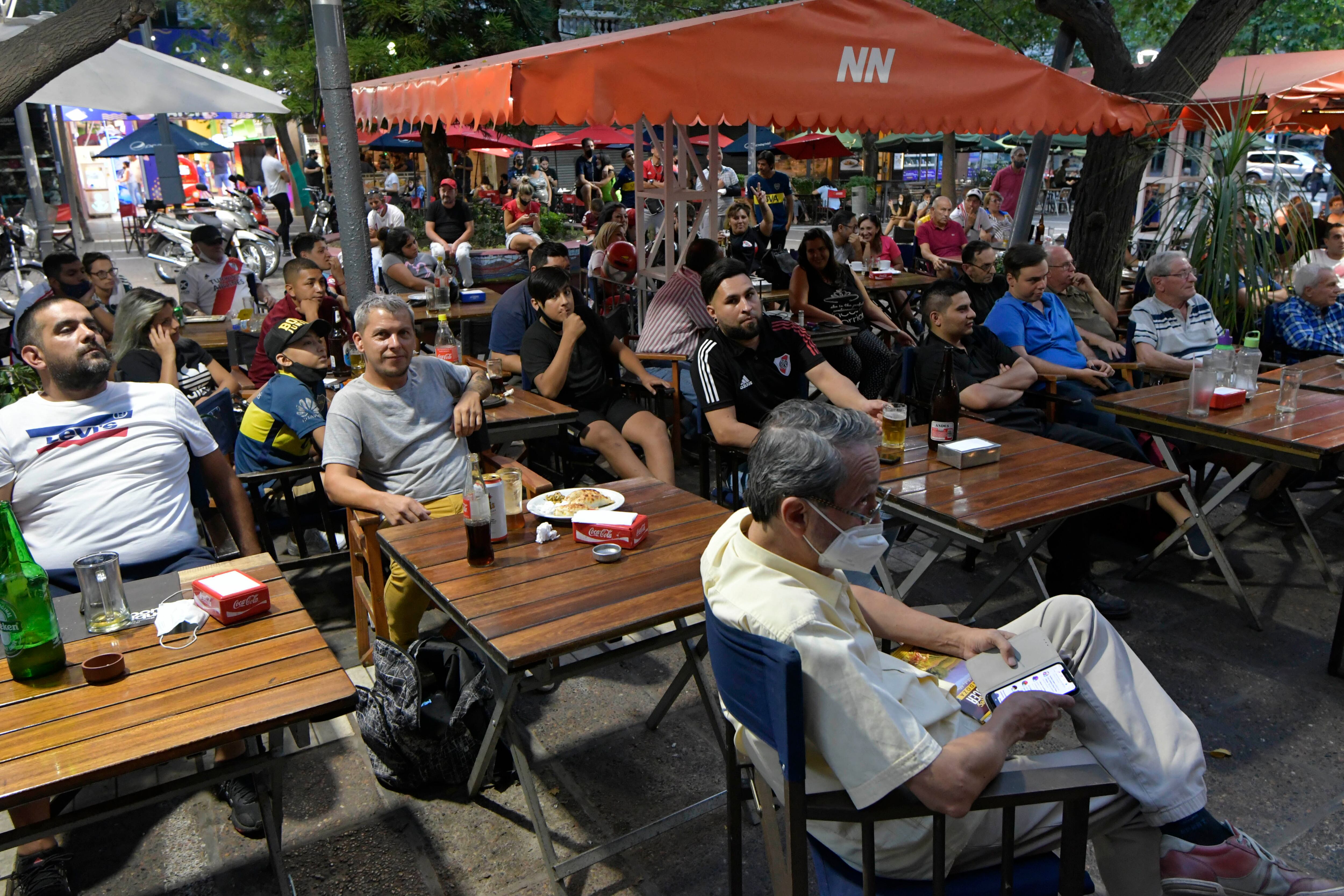 Aficionados observan el super clásico Boca vs River en Peatonal Sarmiento