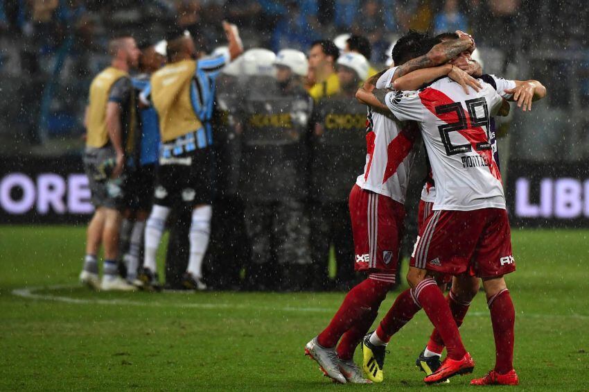 
Foto: AFP | Mientras los jugadores de River festejan, atrás el árbitro Andres Cunha es protegido por la policía de las protestas del equipo de Gremio
   