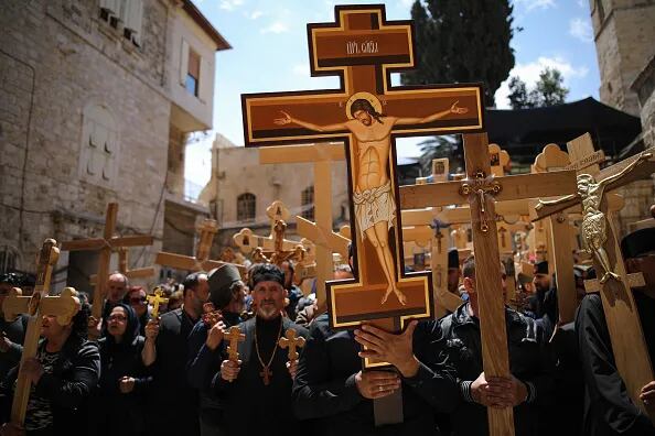 Fieles cristianos llevan cruces a la Iglesia del Santo Sepulcro mientras participan en una procesión del Viernes Santo en la Vía Dolorosa en la Ciudad Vieja de Jerusalén.