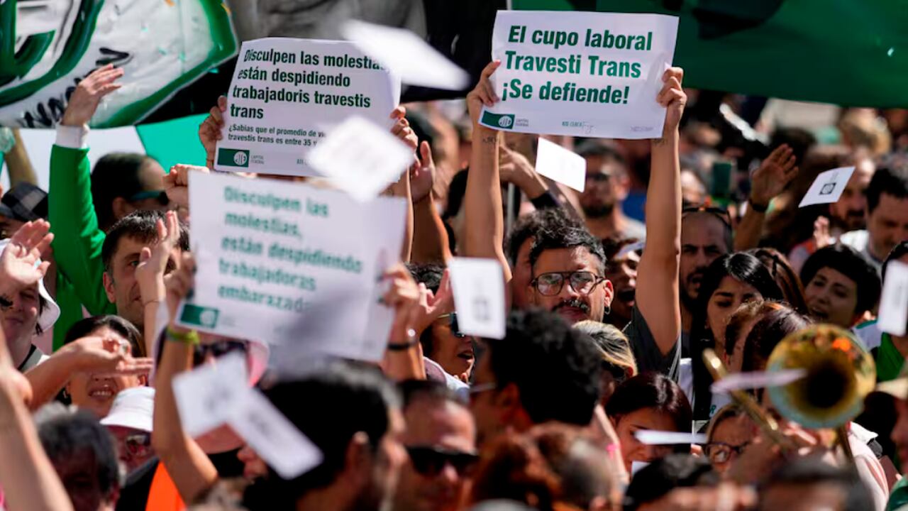 Ariel Heredia, que se identifica como no binario, muestra un cartel a favor del cupo laboral trans en una manifestación que reclama la reincorporación de empleados públicos despedidos, a las afueras del Ministerio de Economía en Buenos Aires. Foto: La Nación