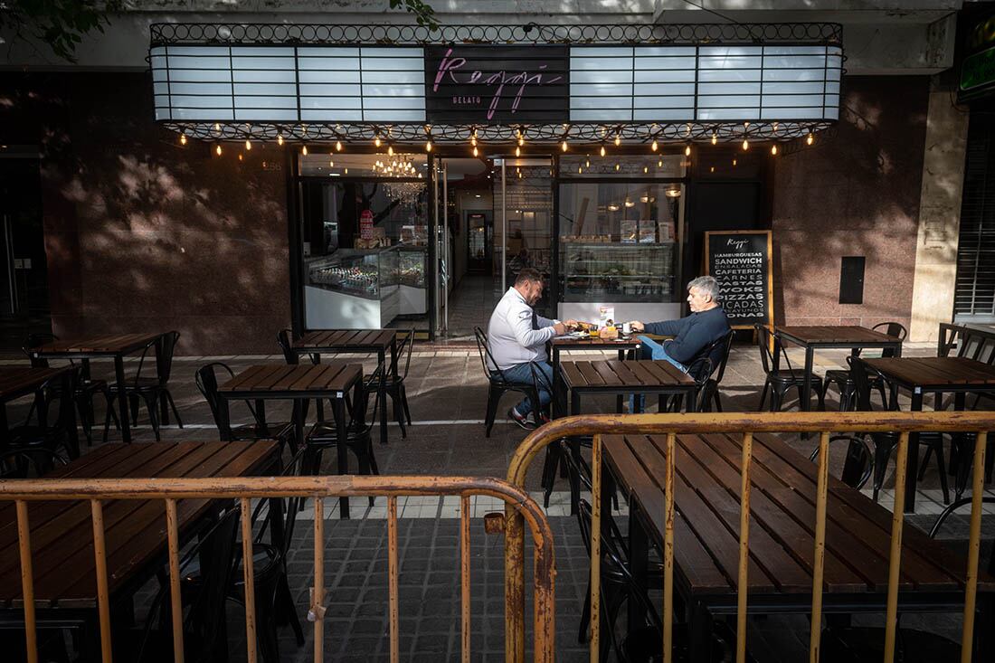 Dos clientes en uno de los pocos cafés abiertos el día del trabajador.