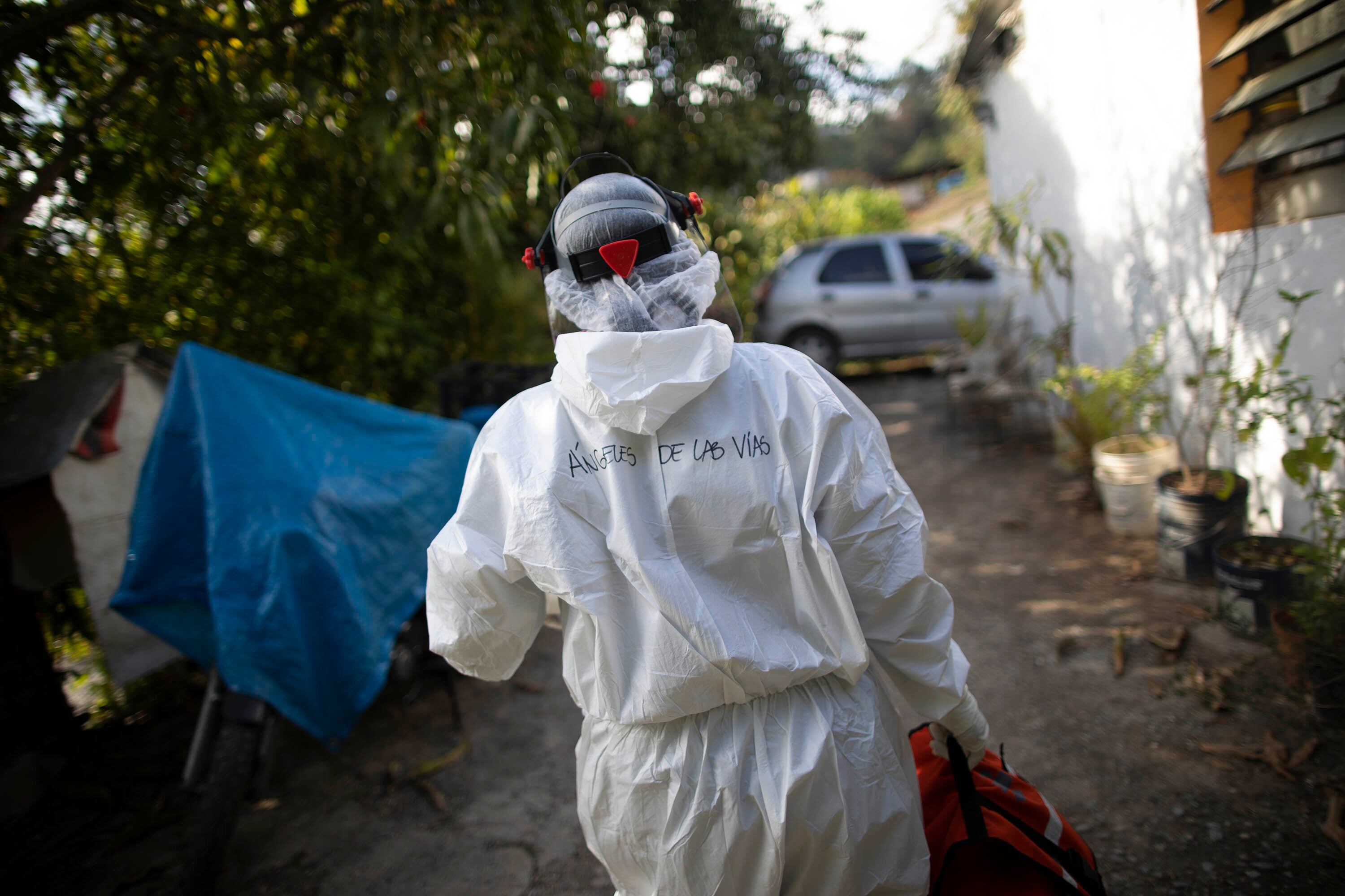 La doctora Débora Mejía, del servicio de voluntarios Ángeles de las Vías, sale de una casa en la que atendió a dos pacientes con COVID-19 en Caracas.