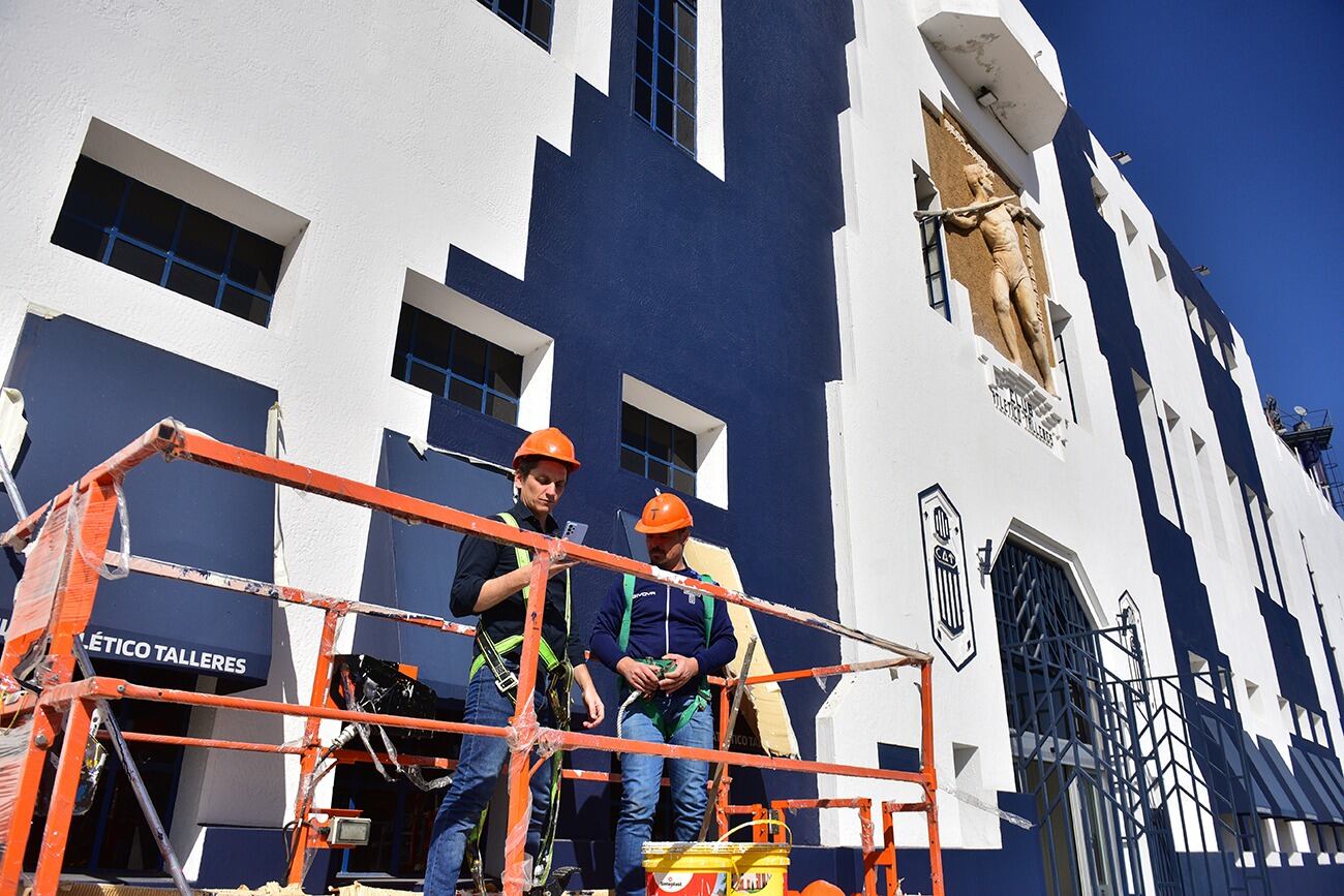 El artista Tec y su equipo en el trabajo de refacción de la fachada de La Boutique de barrio Jardín, el estadio de Talleres. (José Gabriel Hernández / La Voz)