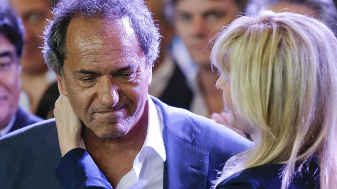 Consuelo. Karina Rabolini abraza a Daniel Scioli, al reconocer la derrota. Atrás, el cordobés Carlos Zannini, quien lo acompañaba en la fórmula (AP)