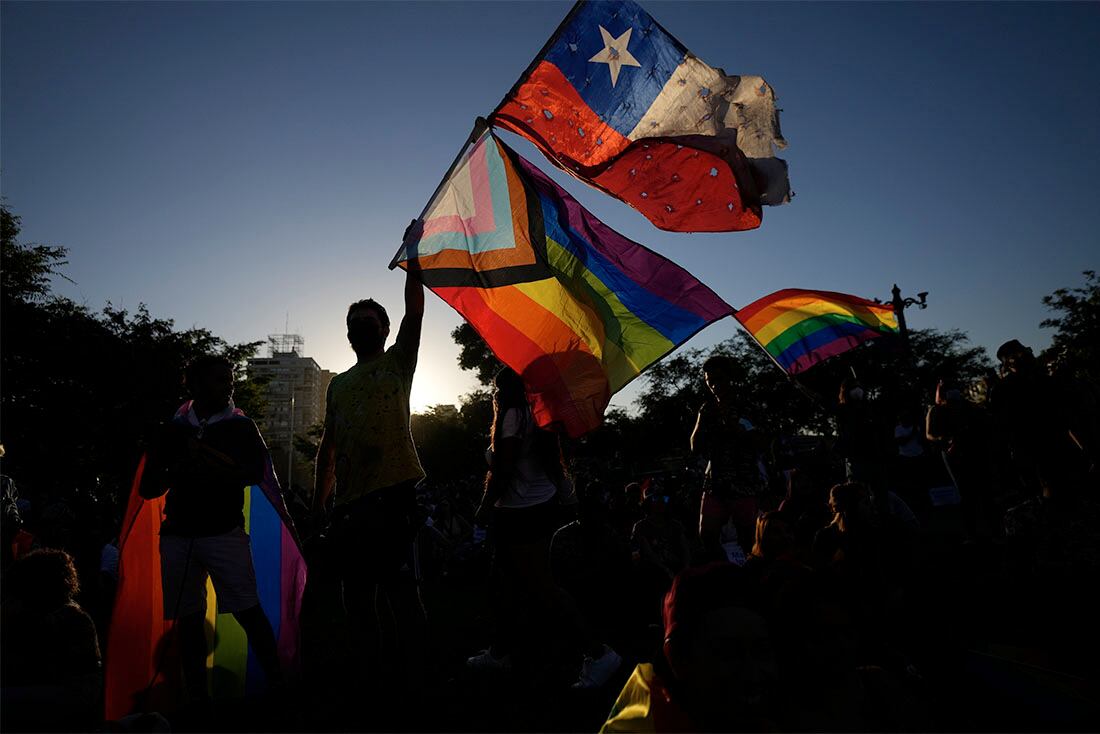 Miembros del Movimiento por la Integración y Liberación Homosexual celebran después de que los legisladores aprobaran una ley que legaliza el matrimonio y la adopción por parejas del mismo sexo, en Santiago, Chile, el martes 7 de diciembre de 2021. (AP Foto/Esteban Felix)