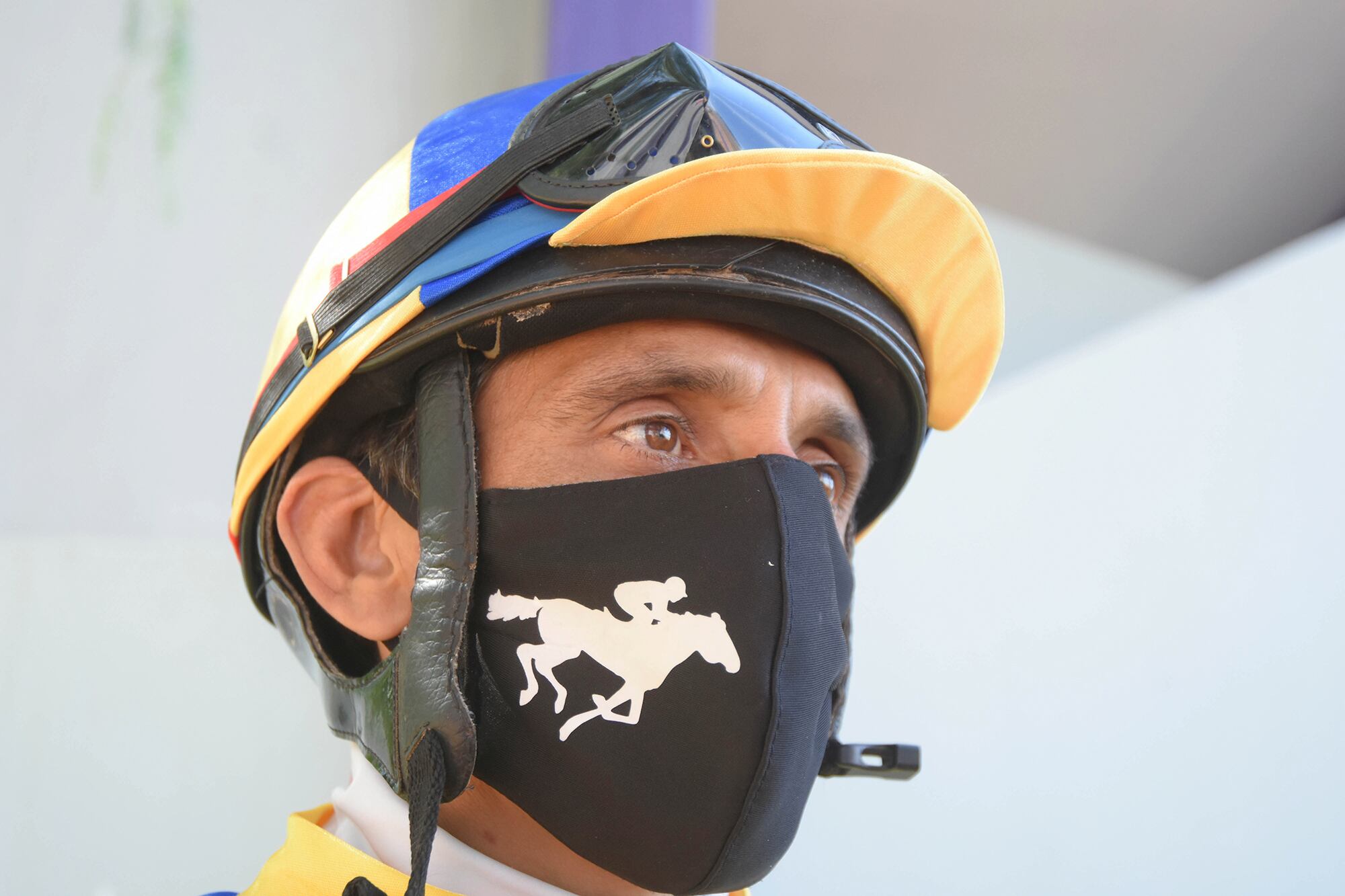 Postal de pandemia. Un Jockey con su tapabocas espera el momento de volver a montar.