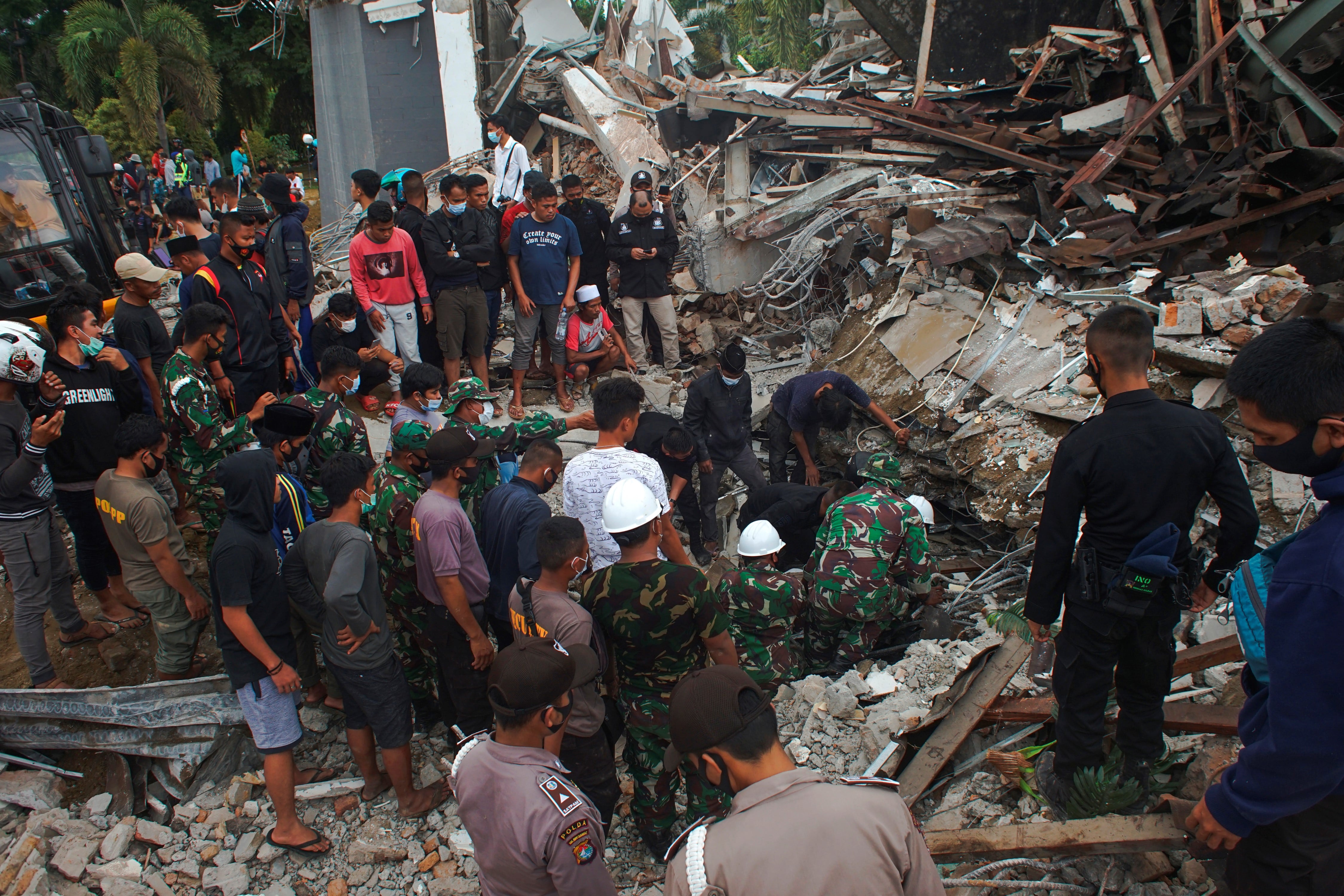  Rescatistas buscan sobrevivientes en las ruinas de un edificio gubernamental que se derrumbó durante un terremoto en Mamuju, West Sulawesi, Indonesia