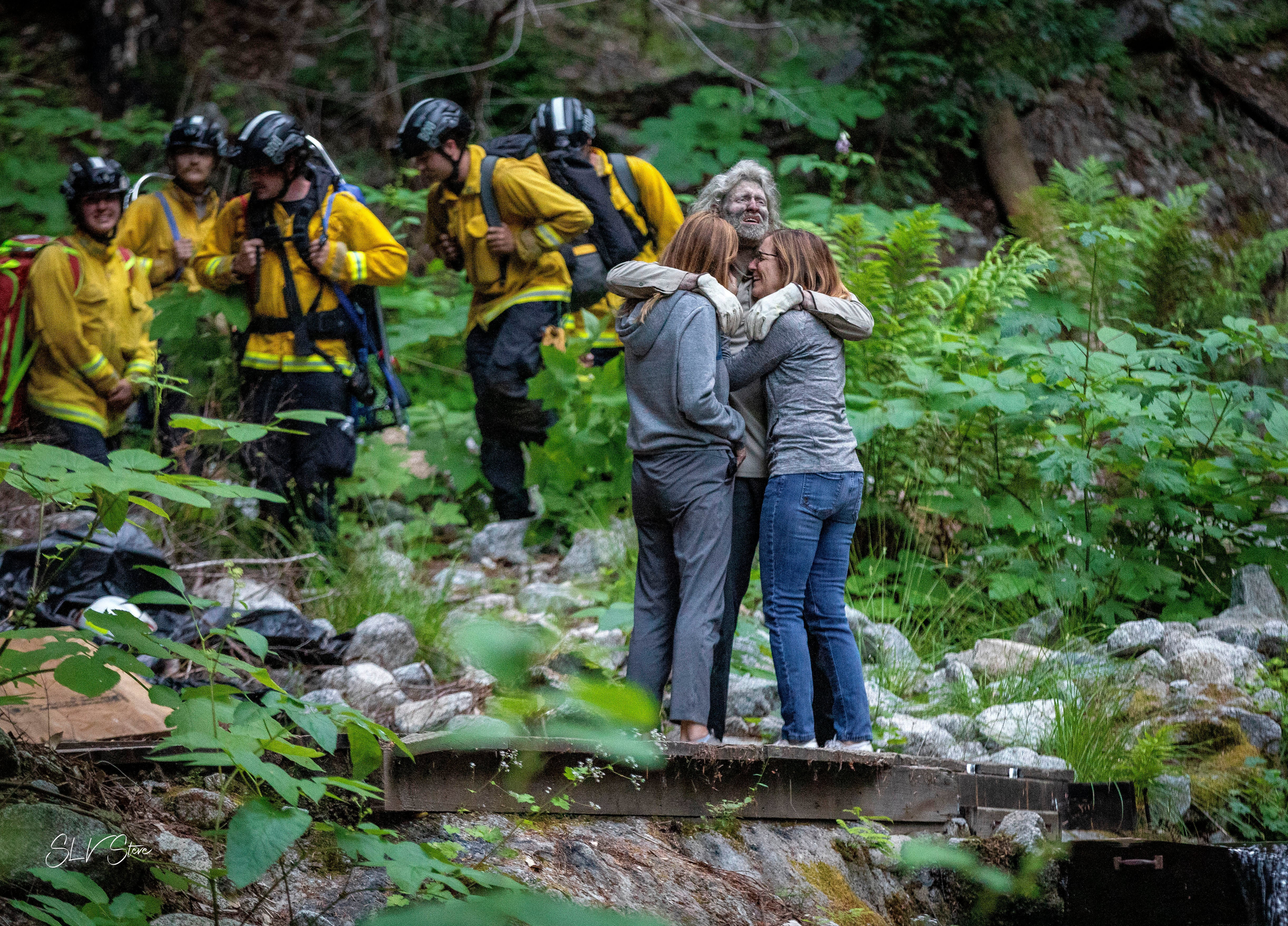 En esta foto proporcionada por SLV Steve, el senderista Lukas McClish, de 34 años, abraza a sus familiares el jueves 20 de junio de 2024 tras haber sido hallado luego de perderse en las montañas, en la comunidad rural de Boulder Creek, California. (SLV Steve vía AP)