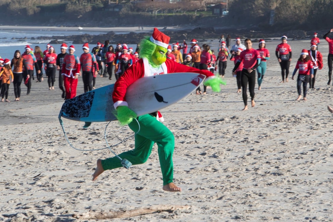 Los "Papá Noeles Surferos" llegan a la playa de Patos en Nigrán durante los festejos previos a la Navidad. Foto: Foto: EFE