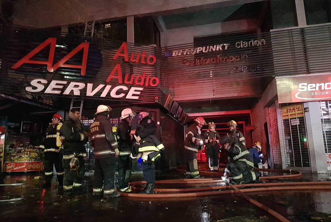 Distintas dotaciones de bomberos, trabajan para combatir un incendio registrado en la noche del domingo en un edificio de avenida Colón en la Ciudad de Mendoza. Foto: Orlando Pelichotti / Los Andes