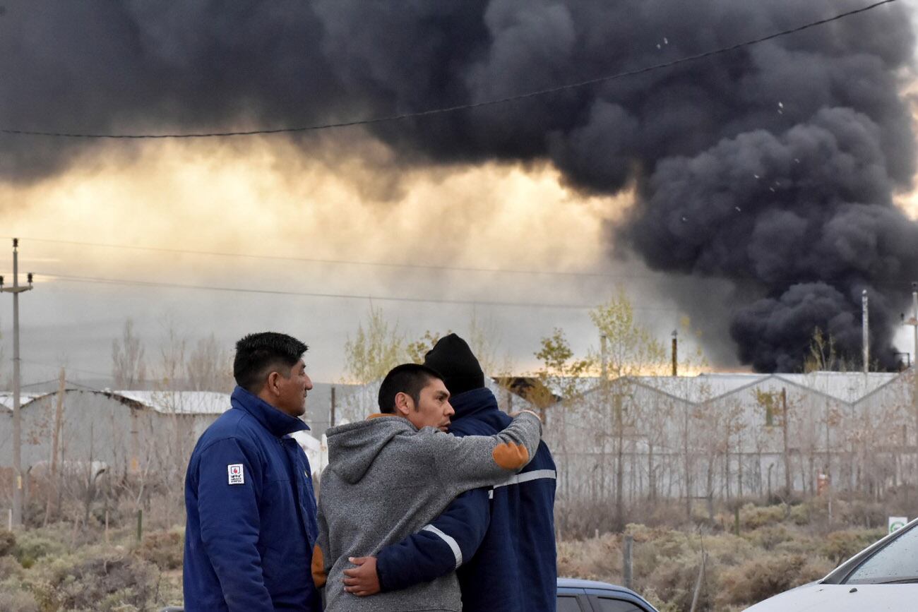 Residentes observan cómo sale humo de la refinería New American Oil (NAO) en Plaza Huincul, provincia de Neuquén, Argentina. Una explosión provocó un gran incendio esta mañana en la refinería NAO, matando a varias personas según informó el alcalde del pueblo. (Fernando Ranni/Diario Rio Negro via AP)