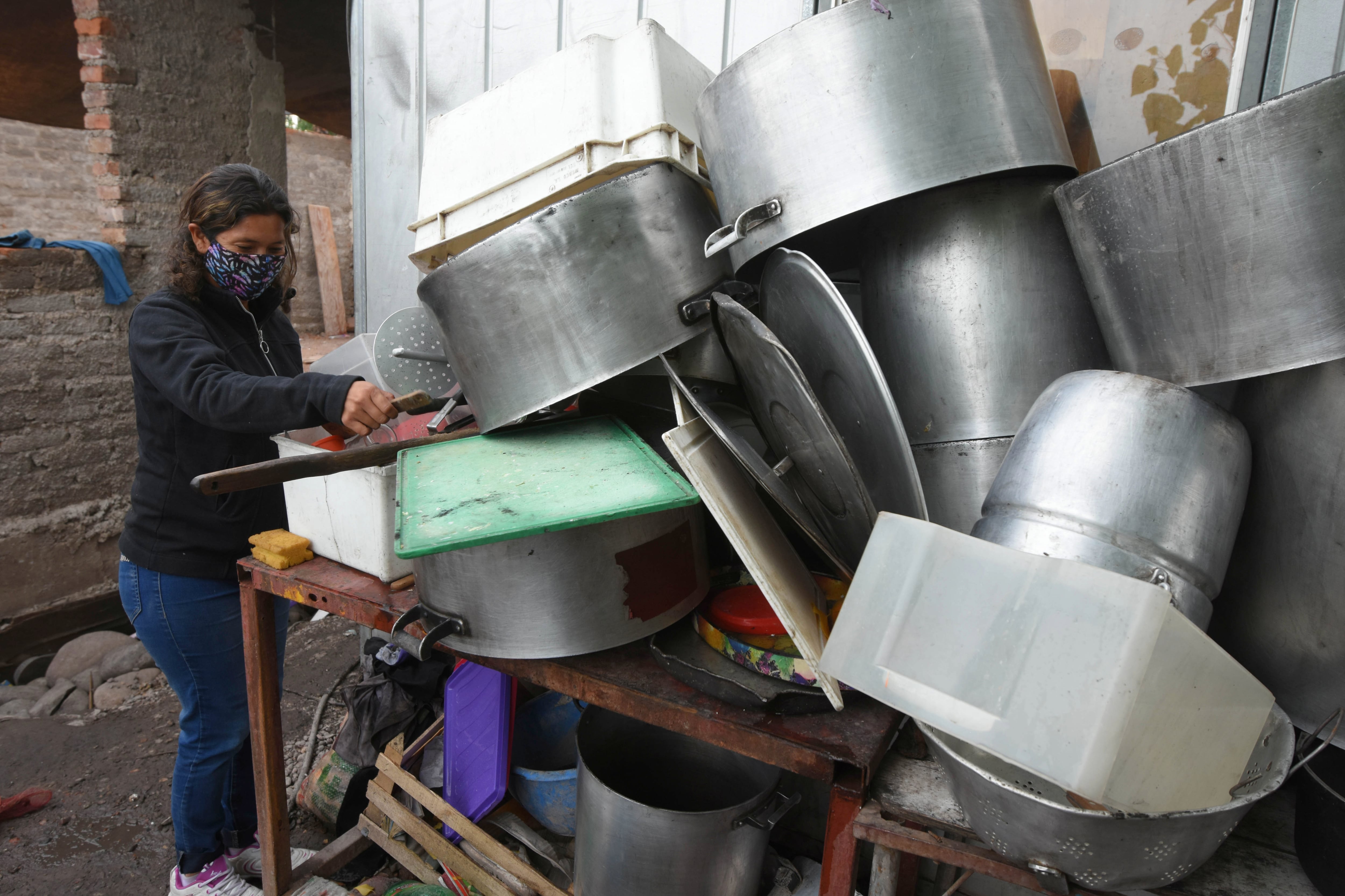 emergencia. Paola coloca las ollas en un rincón para retirar el agua del comedor. Foto: José Gutiérrez / Los Andes. 