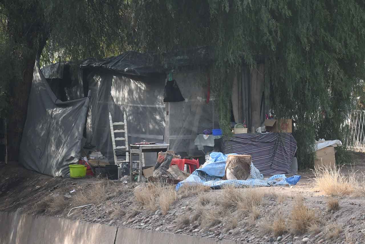 Personas que no tienen donde vivir y están en situación de calle, viven en la Costanera a la orilla del canal Cacique Guaymallén. Foto: Los Andes