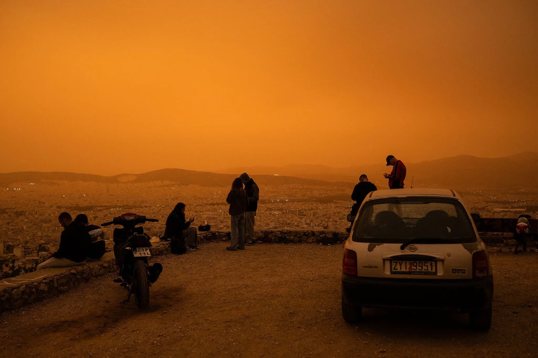 Los atenienses decidieron subir a las colinas para disfrutar desde lo alto del paisaje anaranjado. Foto: EFE