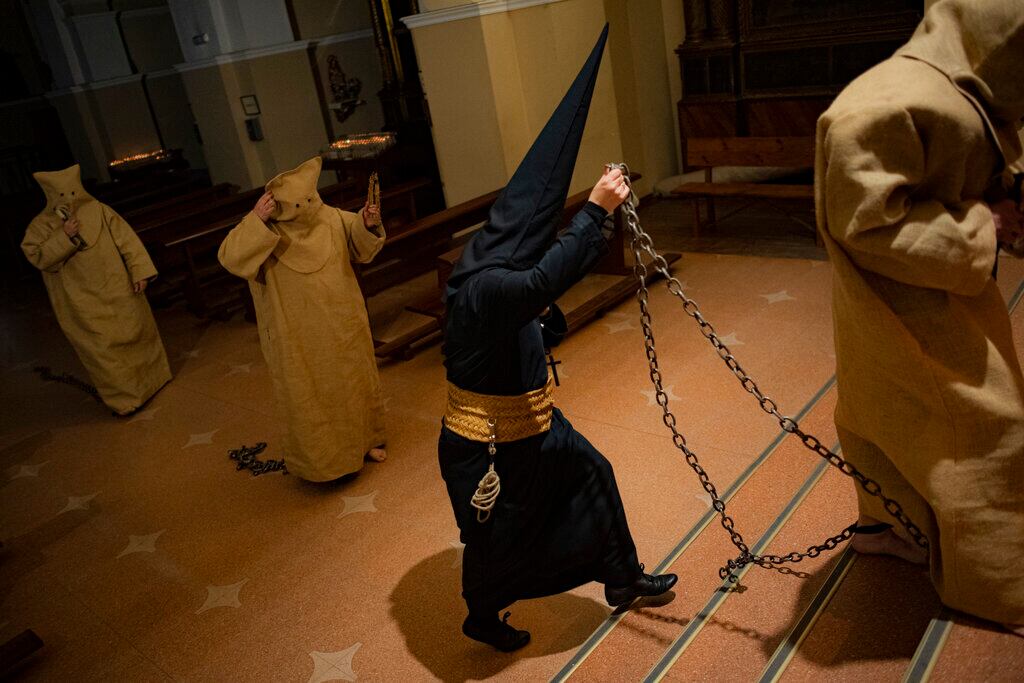 Penitentes, que reciben el nombre de "ensacados", de la cofradía del Silencio del Santísimo Cristo del Rebate, participan en una procesión de Semana Santa en Tarazona, en el norte de España, el 12 de abril de 2022. (AP Foto/Álvaro Barrientos)