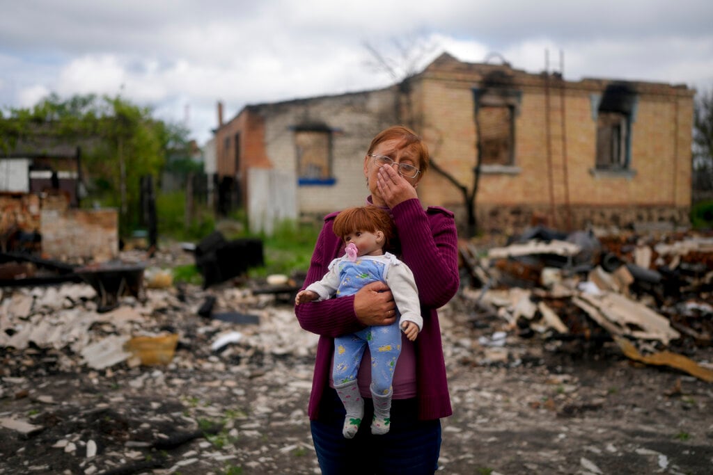 Nila Zelinska sostiene una muñeca de su nieta que encontró en su casa destruida por artillería rusa en las afueras de Potashnya, Kiev, Ucrania.. Foto AP