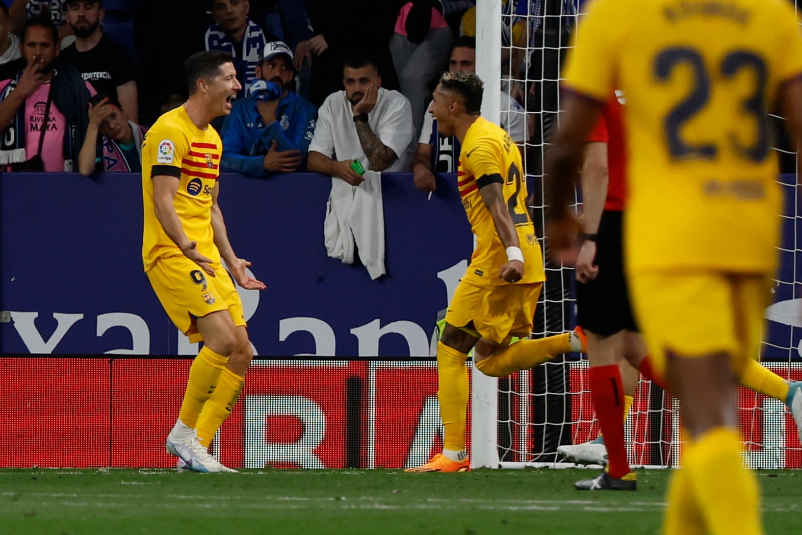 Robert Lewandowski (izquierda) celebra tras anotar el tercer gol del Barcelona en el partido contra enl Espanyol en la Liga española, el domingo 14 de mayo de 2023. (AP Foto/Joan Monfort)