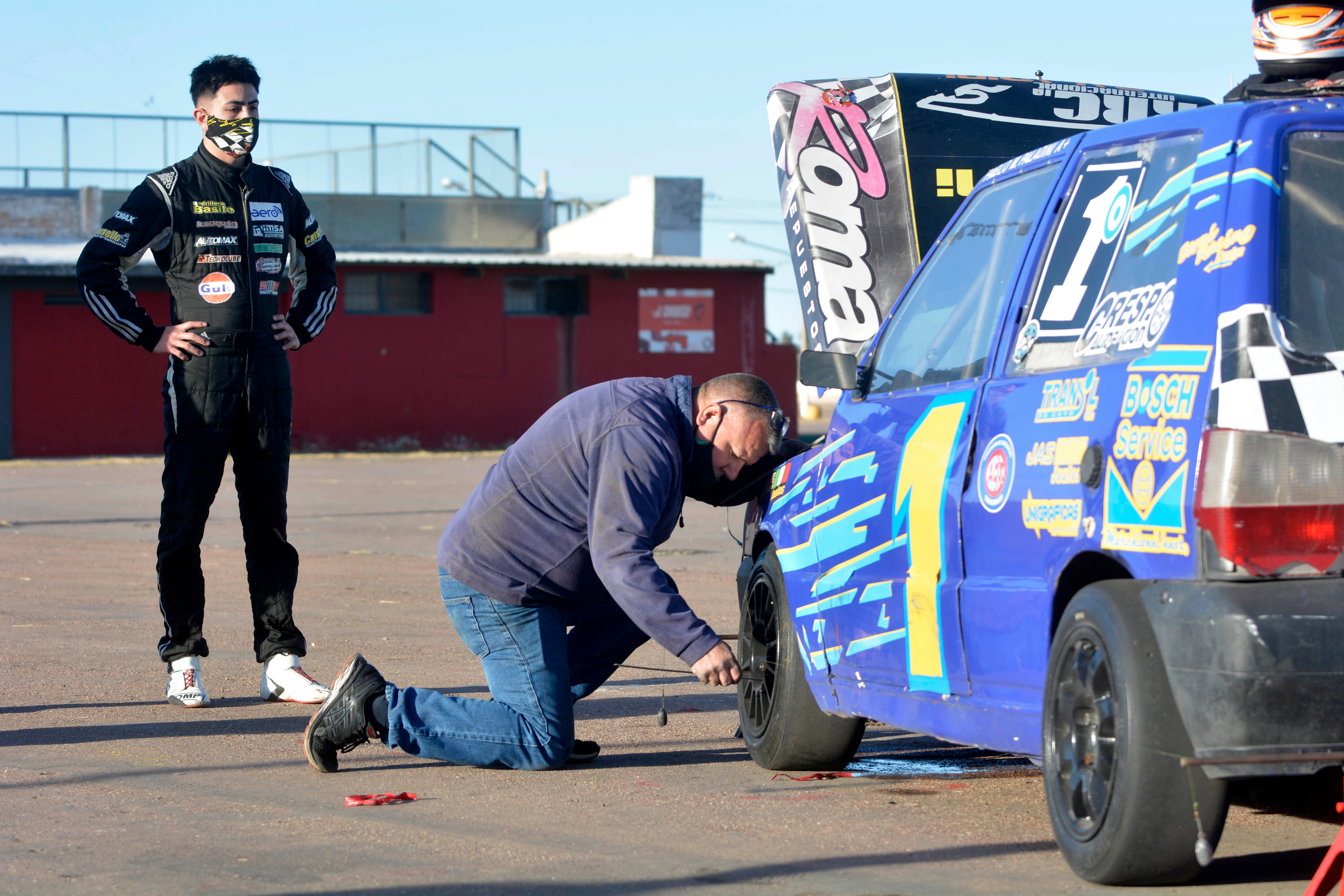 Un ayudante de Danilo Gil, el primer piloto en probar el circuito, controla el estado de las cubiertas.