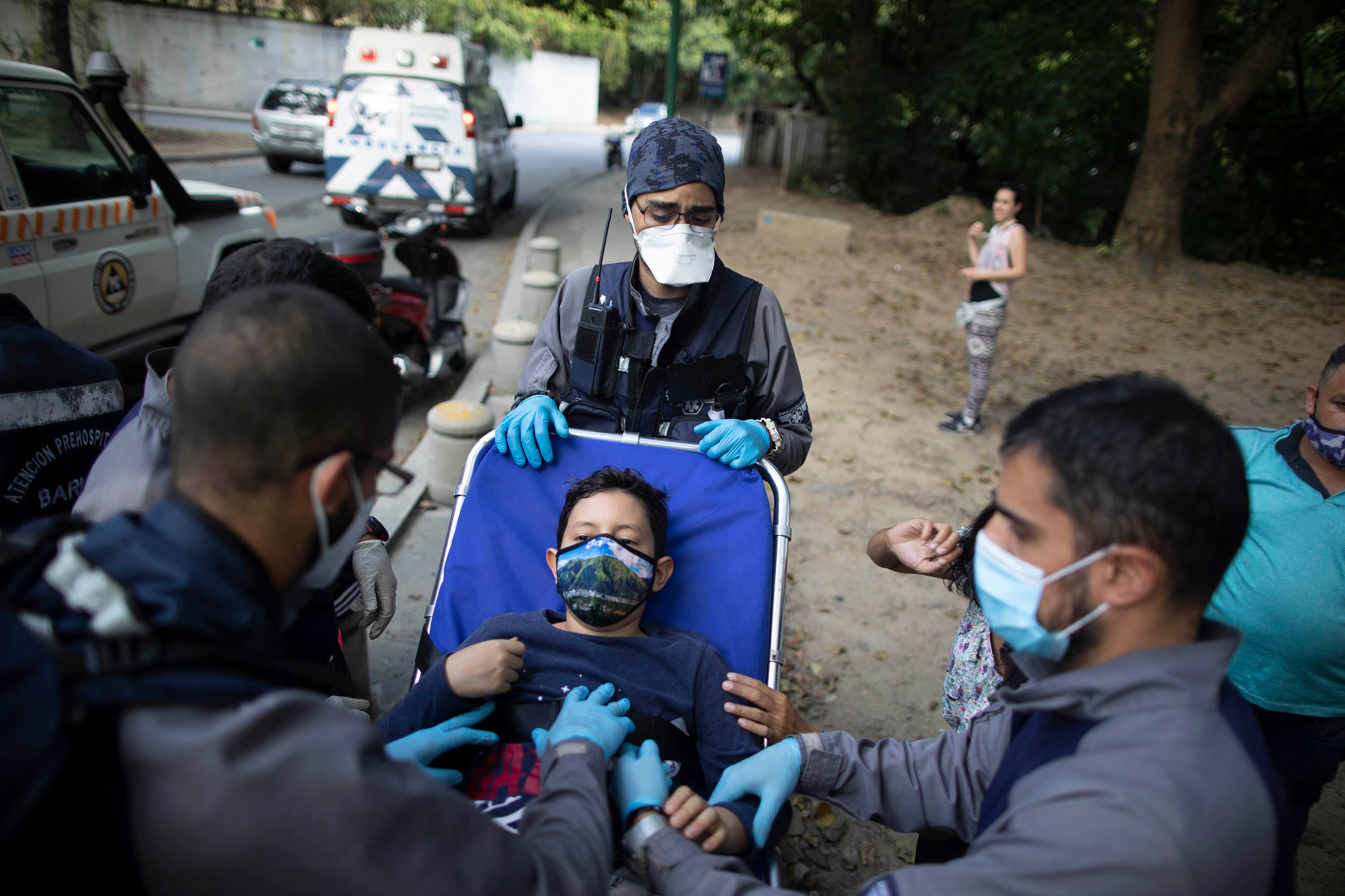 Voluntarios transportan en camilla a un niño herido en un accidente.