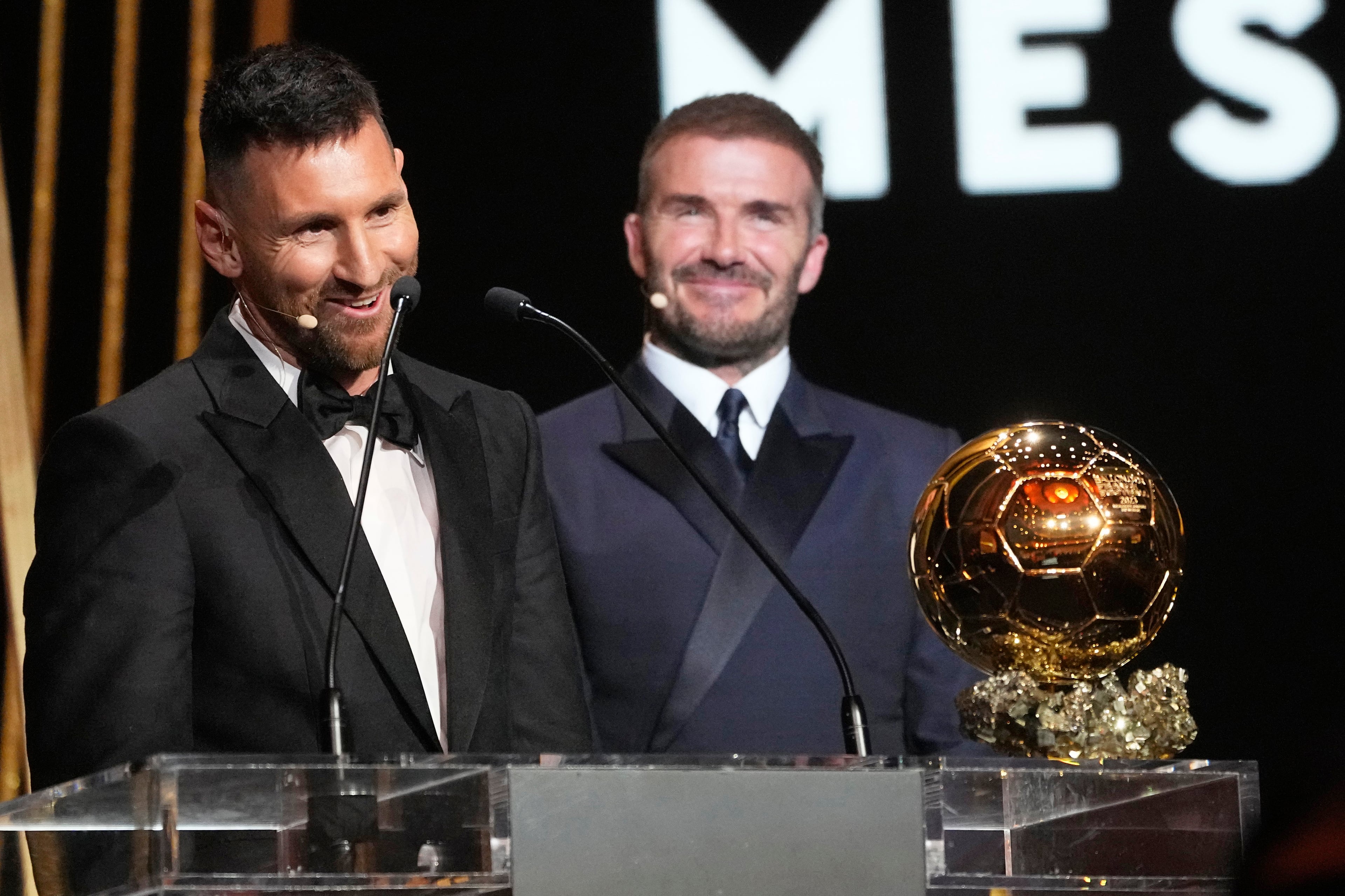 El co propietario del Inter Miami y ex estrella del fútbol mundial David Beckham, derecha, sonríe mientras Lionel Messi, futbolista argentino campeón del mundo con Argentina, recibe el Balón de Oro 2023 en la 67ma ceremonia de premiación del Balón de Oro, en el Theatre du Chatelet en Paris, Francia, el lunes 30 de octubre de 2023. (AP Foto/Michel Euler)