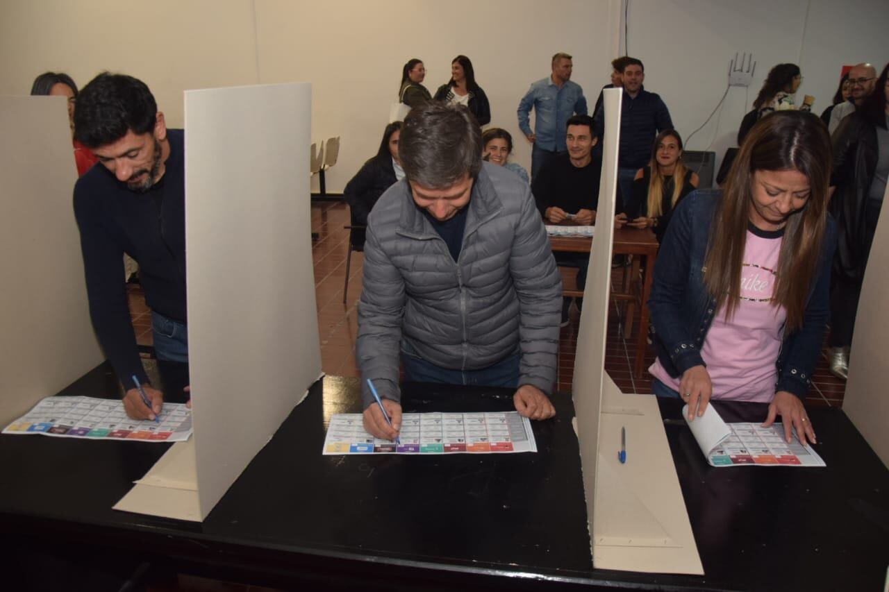 Simulación sobre cómo serían las votaciones con Boleta Única. El presidente de mesa entrega la boleta al votante, quien se dirige a un box a marcar sus preferencias, dobla la boleta y vuelve a la mesa a poner su voto en la urna. Gentileza Prensa UCR.