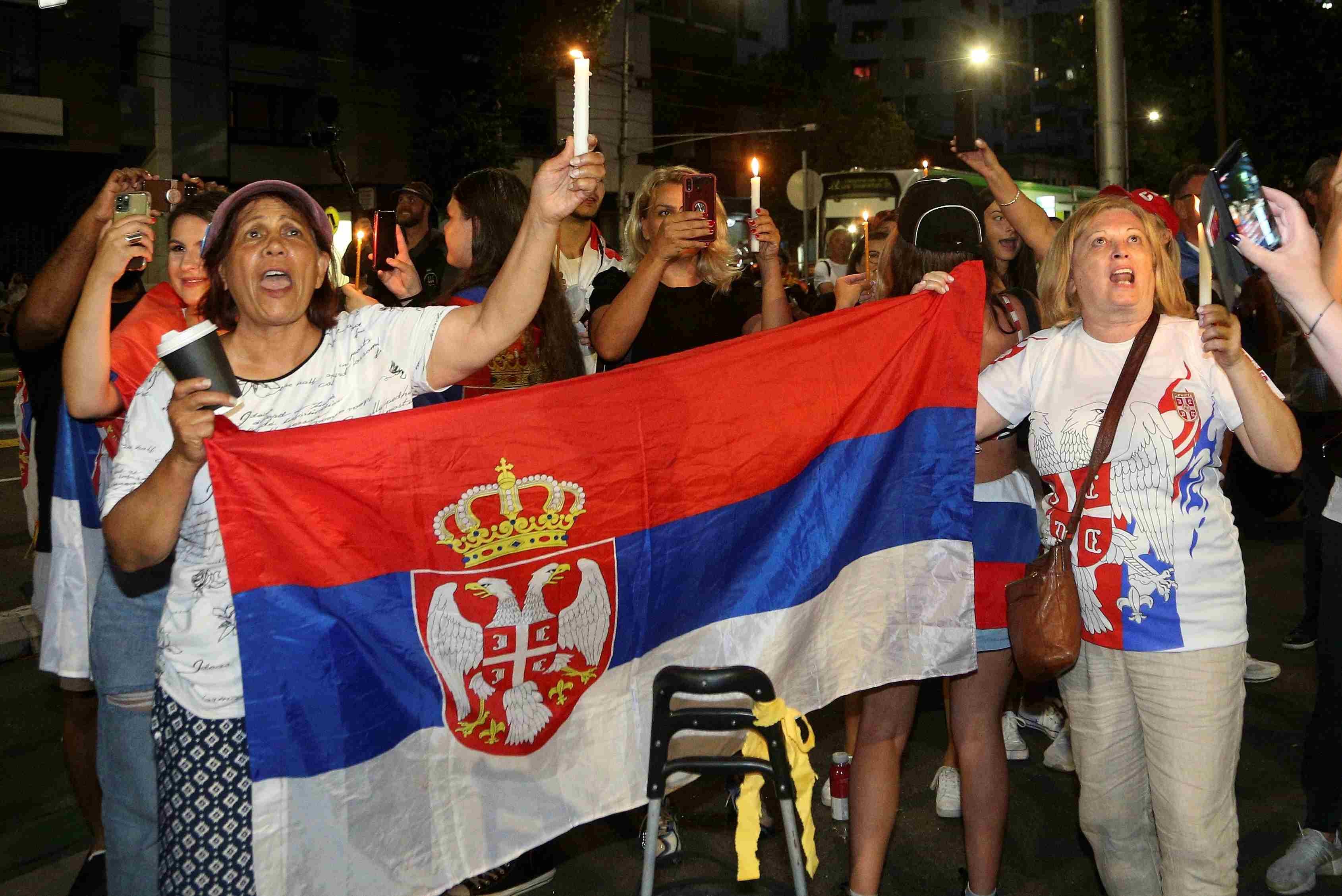 Seguidores de Novak Djokovic manifiestan su apoyo al tenista en las afueras del hotel de Australia. (AP)