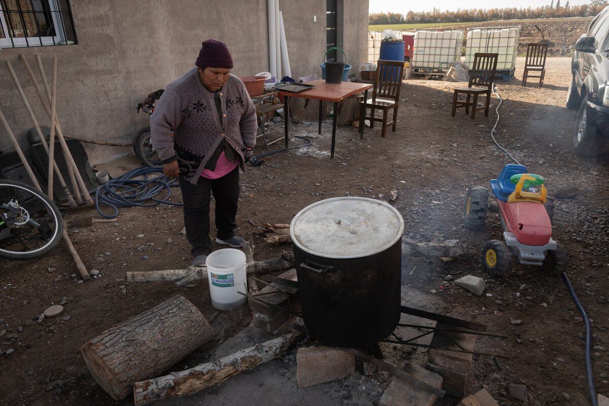 Yolanda Amador calienta agua fuera de la casa propia a la que se mudaron recientemente, en Las Violetas (Lavalle). Foto: Ignacio Blanco / Los Andes