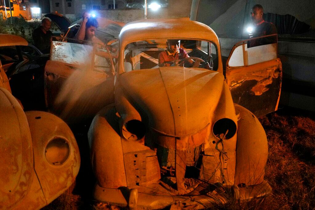 Mecánicos revisan un Opel Olympia 1952 de fabricación alemana el viernes 8 de abril de 2022, en la ciudad El Saff, en las afueras de El Cairo, Egipto. Mohamed Wahdan, un empresario egipcio y coleccionista de vehículos clásicos, dice haber acumulado más de 250 automóviles vintage, antiguos y clásicos en los últimos 20 años. (AP Foto/Amr Nabil)