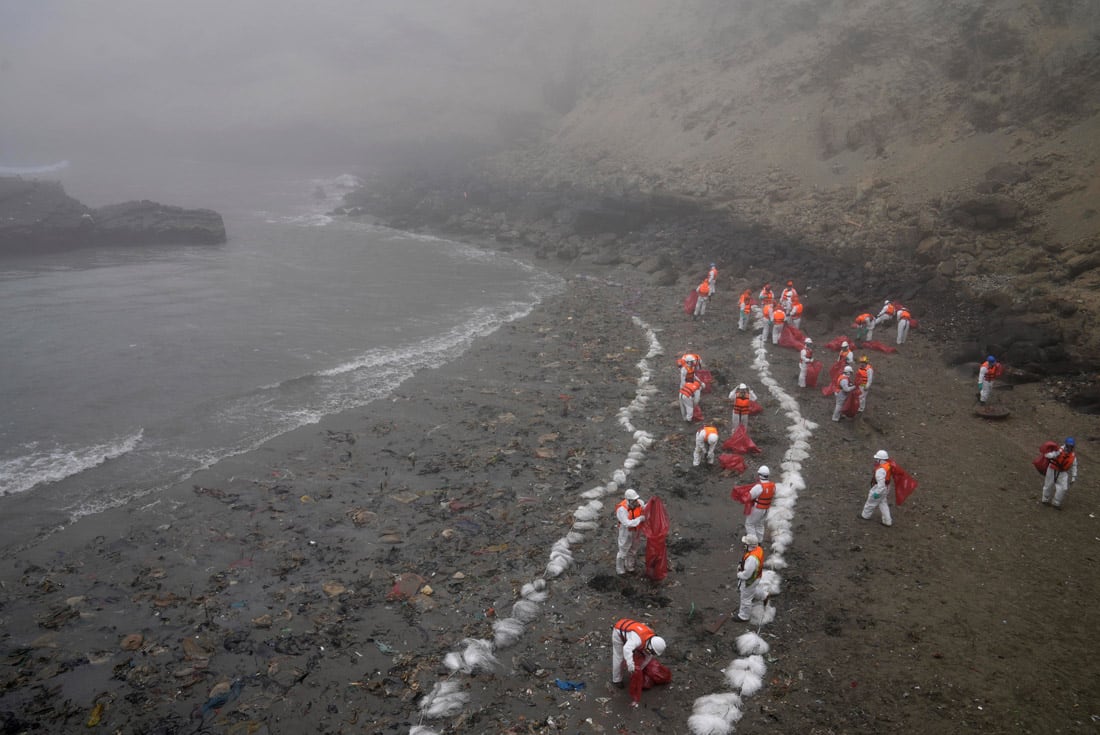 Trabajadores continúan limpiando las playas contaminadas en Playa Cavero, Perú, un mes después del derrame de un buque petrolero de Repsol. (AP)