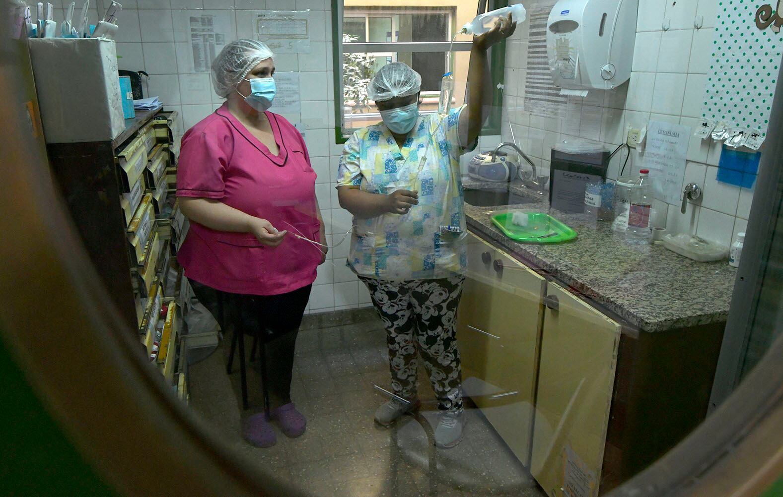 En el Servicio de Internación Pediátrica, del Hospital Pediátrico Humberto Notti, las enfermeras Liliana Mendoza junto a Anabel Garro, preparan las guías del suero para administrar a los pacientes.
Foto: Orlando Pelichotti / Los Andes