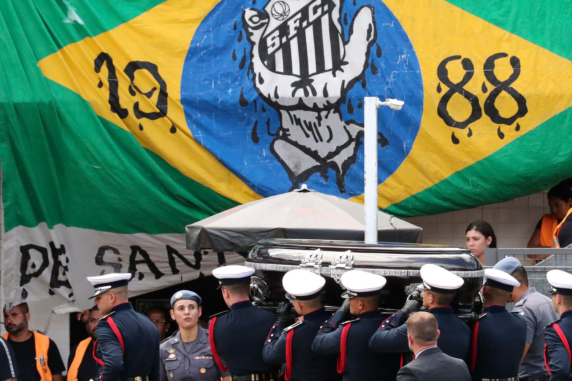 Miembros de una guardia de honor cargan el féretro con el cuerpo de la leyenda del fútbol Edson Arantes do Nascimento, 'Pelé, hoy, tras finalizar su velatorio en el estadio Vila Belmiro en la ciudad de Santos (Brasil). / Foto: EFE / Sebastiao Moreira

