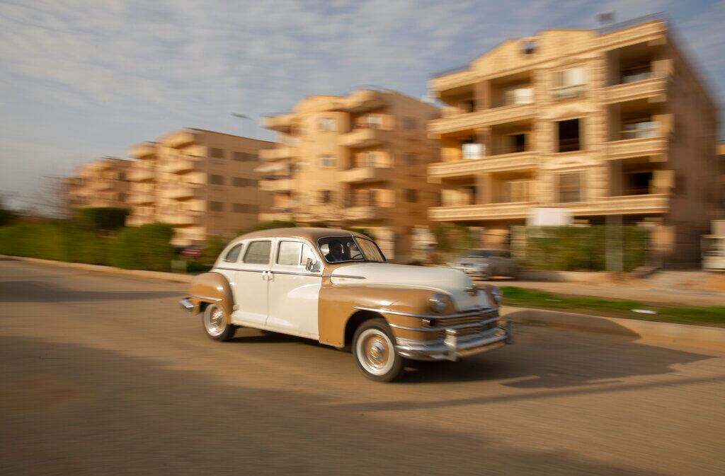 El coleccionista egipcio Mohamed Wahdan conduce un Chrysler 1948 el 1 de marzo de 2022, en la ciudad de Obour, cerca de El Cairo, Egipto. Durante más de 20 años, el empresario de 52 años ha logrado coleccionar una flota de más de 200 coches vintage, antiguos y clásicos. (AP Foto/Amr Nabil)