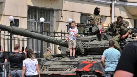 Un niño es fotografiado por sus padres sobre un tanque del Grupo Wagner en las calles de Rostov, en Rusia.