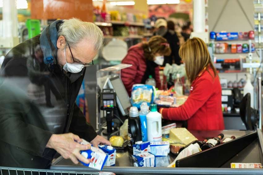 
Gente con barbijos en la cola del supermercado para evitar el contagio del coronavirus, en  Casalpusterlengo, norte de Italia | AFP
   