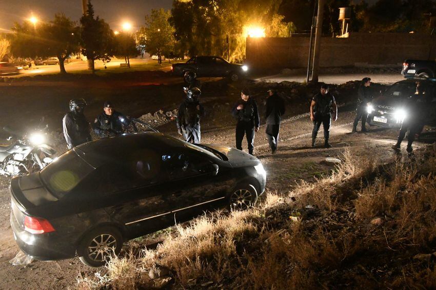 
Policías rodean un automóvil sospechoso e identifican a los dos ocupantes, en una oscura zona del barrio Los Barrancos. | José Gutiérrez / Los Andes
   