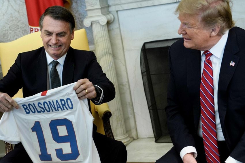 
Bolsonaro le entregó a Trump la camiseta de la selección masculina de fútbol, mientras que el norteamericano le obsequió una del equipo femenino. | AFP
   