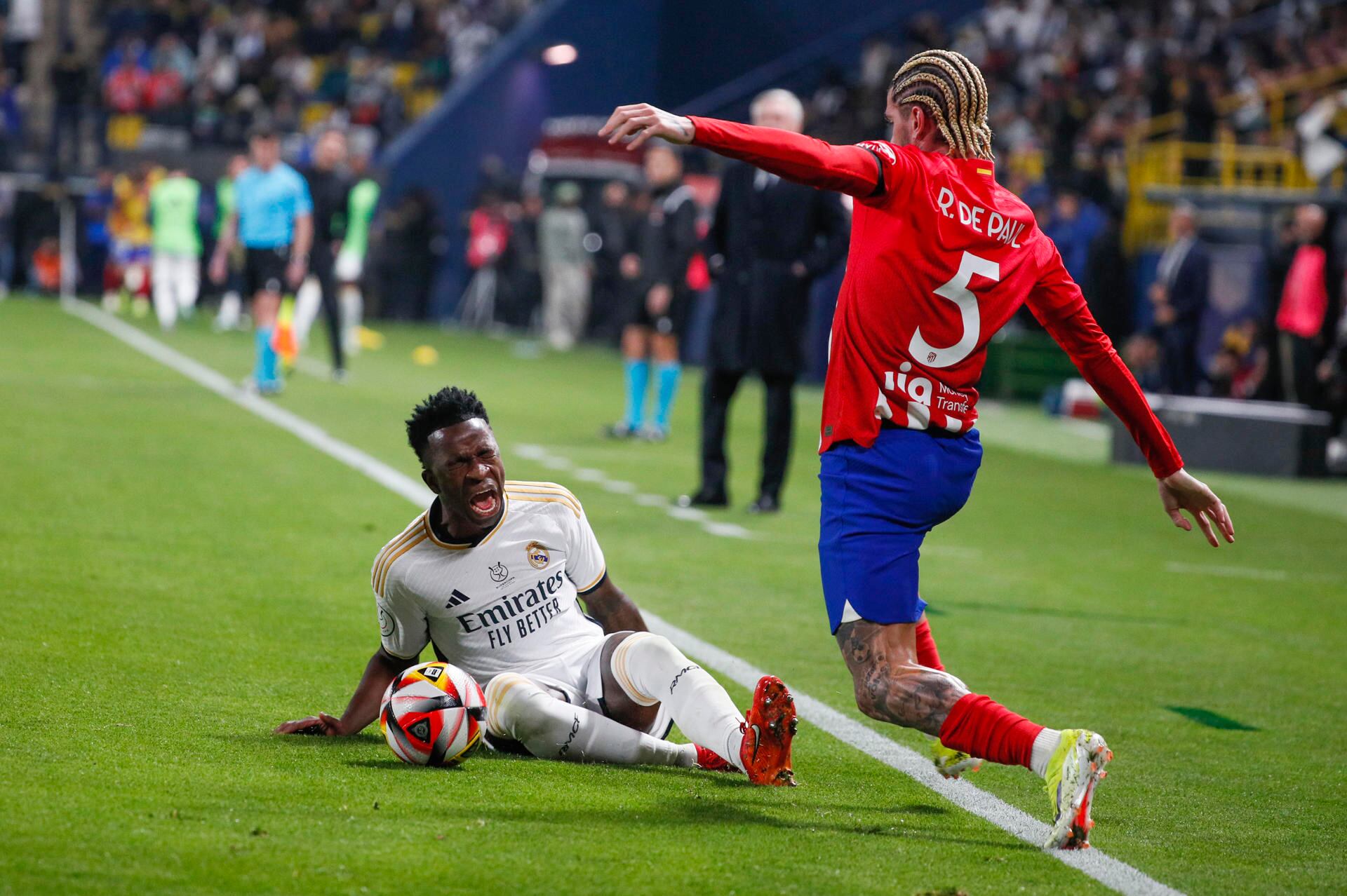 El delantero brasileño del Real Madrid Vinicius Junior (i) disputa un balón con el centrocampista argentino del Atlético de Madrid Rodrigo de Paul durante el encuentro de semifinales de la Supercopa de España entre Real Madrid y Atlético de Madrid, este miércoles en el estadio Al Awwal Park en Riad, Arabia Saudí. EFE / Juan Carlos Cárdenas