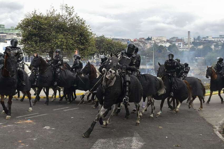 
Foto: AFP | La policía antidisturbios montada dispersa a los manifestantes fuera de la asamblea nacional en Quito.
   