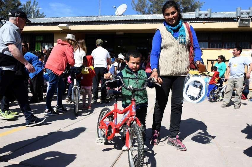 
Carlos junto a su bicicleta que usará para jugar, pasear, visitar a sus amigos de puestos cercanos y para ir a clases. | Marcelo Rolland / Los Andes
   