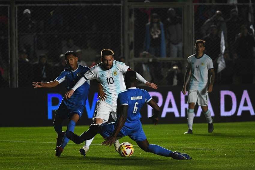 
Marcelo Rolland / 07 de junio | Lionel Messi esquiva a 2 jugadores en el amistoso internacional frente a Nicaragua en San Juan.
   