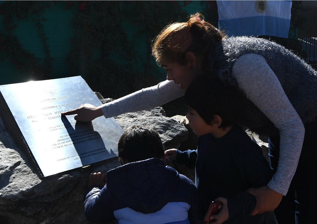 La viuda de Cussi les muestra a sus hijos la placa que lleva su nombre en la ruta 82.| Foto: Marcelo Rolland / Los Andes